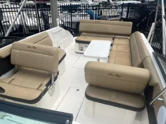 Slide: The Image of 2022 Sea Ray SDX 250 boat interior with beige seating and a central table. - 6
