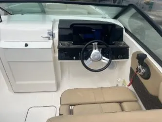 Slide: The Image of 2022 Sea Ray SDX 250 boat interior with steering wheel and beige seating. - 8