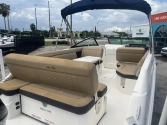Slide: The Image of 2022 Sea Ray SDX 250 boat with tan seating and blue canopy, docked outdoors. - 9