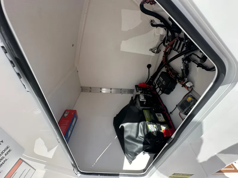 Slide: The Image of Interior view of 2026 Twin Vee 22 Bay Cat boat compartment with battery and wiring. - 12