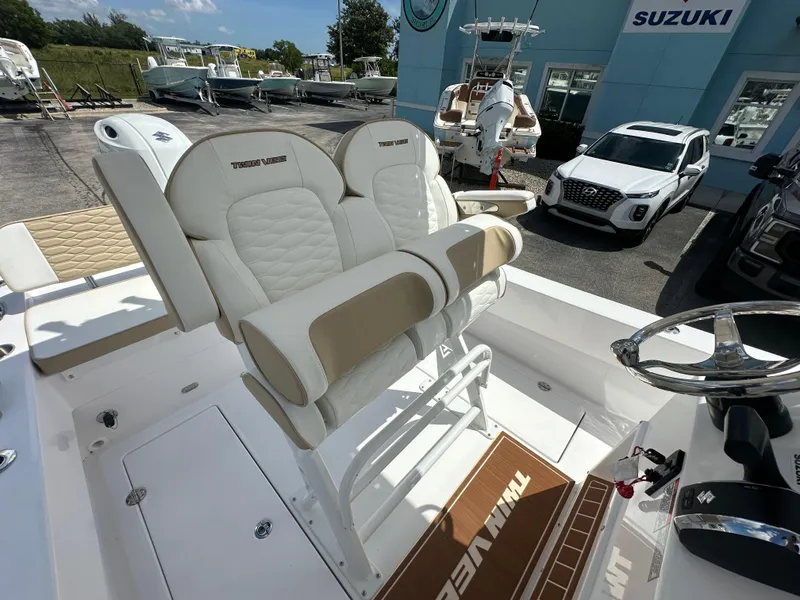 Slide: The Image of 2026 Twin Vee 22 Bay Cat boat interior with dual seats and steering wheel. - 13