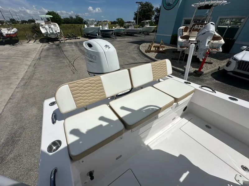 Slide: The Image of 2026 Twin Vee 22 Bay Cat boat with cushioned seating and Suzuki outboard motor. - 14