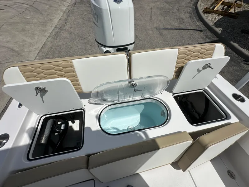 Slide: The Image of 2026 Twin Vee 22 Bay Cat boat with open storage compartments and seating. - 15