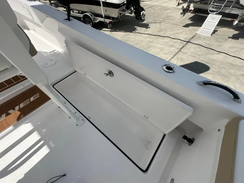 Slide: The Image of 2026 Twin Vee 22 Bay Cat boat with open storage compartment on deck. - 16
