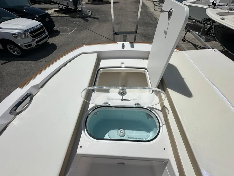 Slide: The Image of 2026 Twin Vee 22 Bay Cat boat with open storage compartments and livewell. - 8