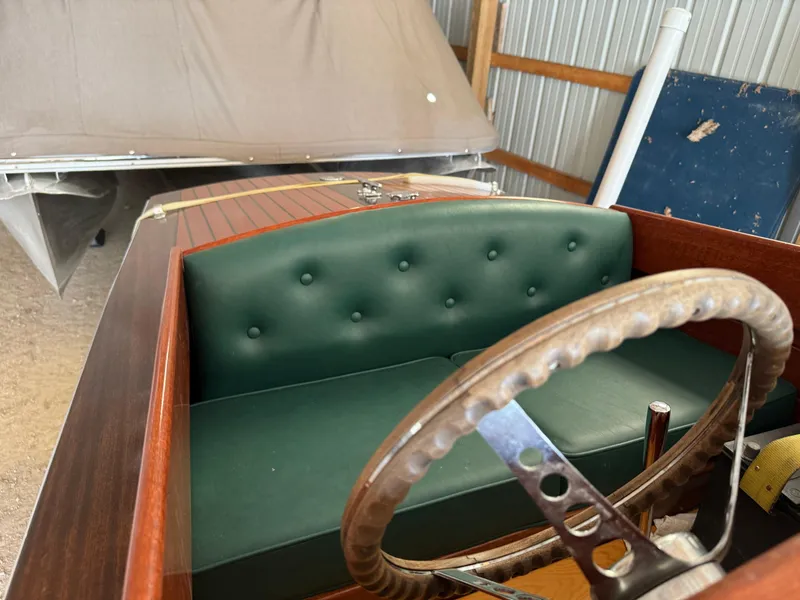 Slide: The Image of Interior of 2010 Hacker-Craft Gentleman's Racer Replica with wooden steering wheel and green seats. - 5