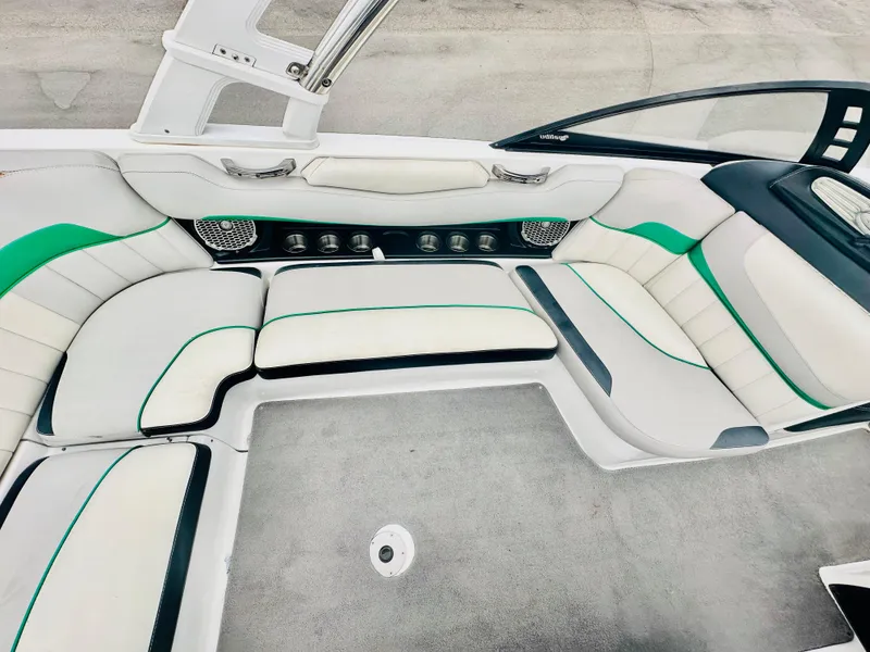 Slide: The Image of Interior of a 2012 Malibu 22mxz boat with white and green seating. - 10