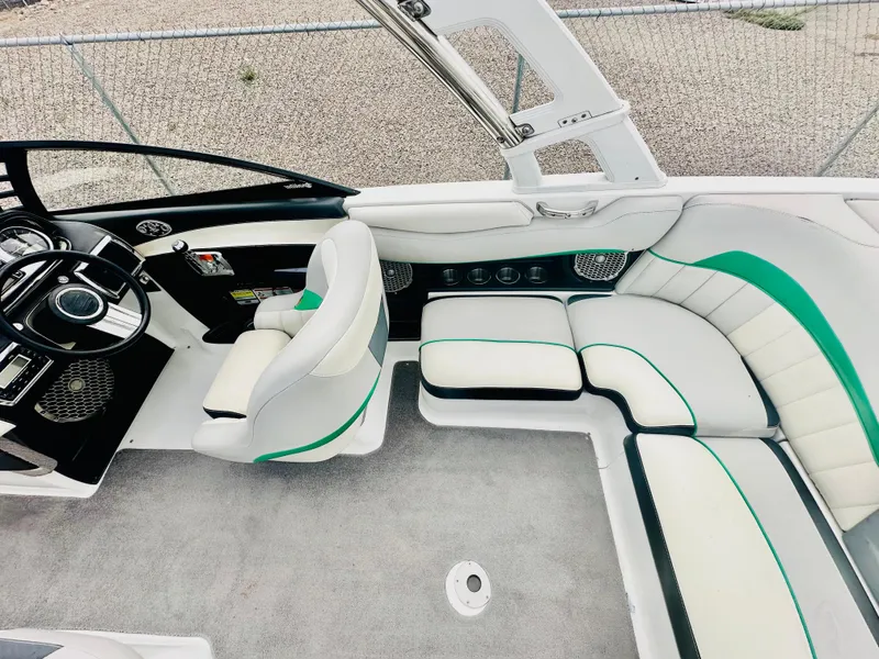Slide: The Image of Interior of 2012 Malibu 22mxz boat with white and green seating, modern dashboard. - 11