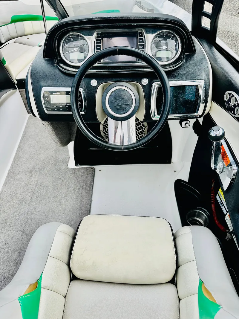 Slide: The Image of 2012 Malibu 22mxz boat dashboard with steering wheel and control panel. - 12