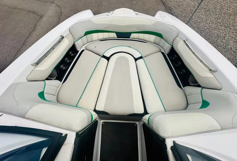 Slide: The Image of 2012 Malibu 22mxz boat interior with white and green cushioned seating. - 13
