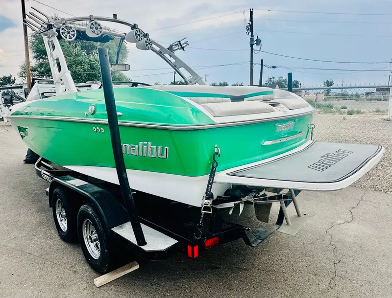 Slide: The Image of 2012 Malibu 22mxz boat in vibrant green on a trailer, rear view. - 6