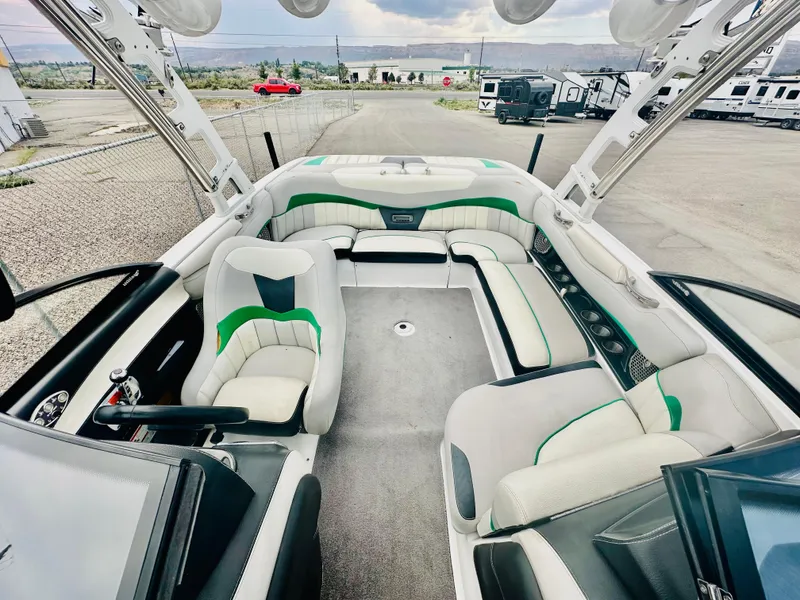 Slide: The Image of Interior of a 2012 Malibu 22mxz boat with white and green seating. - 8