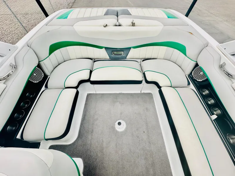 Slide: The Image of Interior of a 2012 Malibu 22mxz boat with white and green seating. - 9