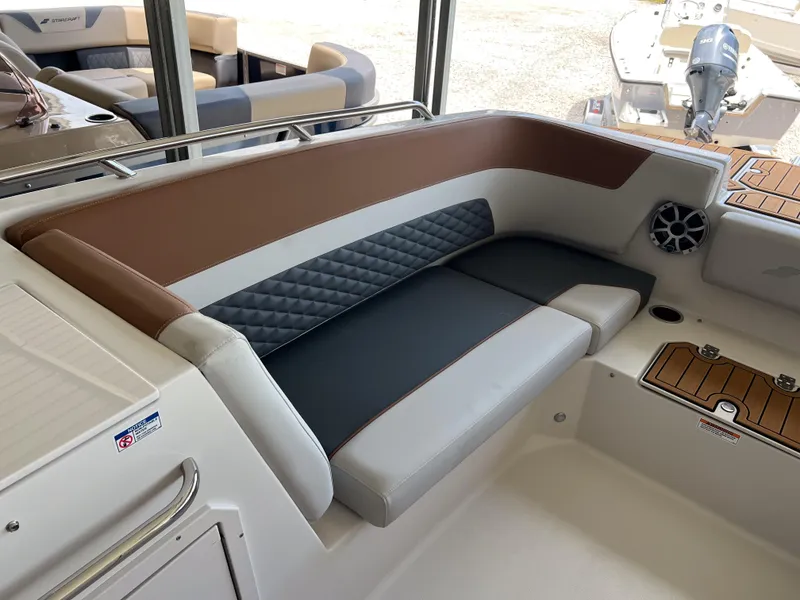 Slide: The Image of 2026 Starcraft SVX 231 OB boat interior with cushioned seating and speaker system. - 18