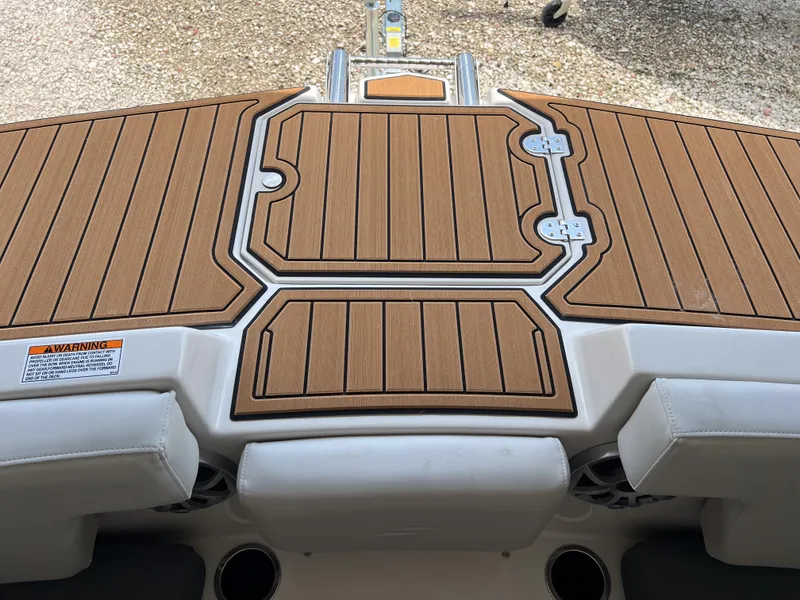 Slide: The Image of 2026 Starcraft SVX 231 OB boat deck with teak-style flooring and warning label. - 22
