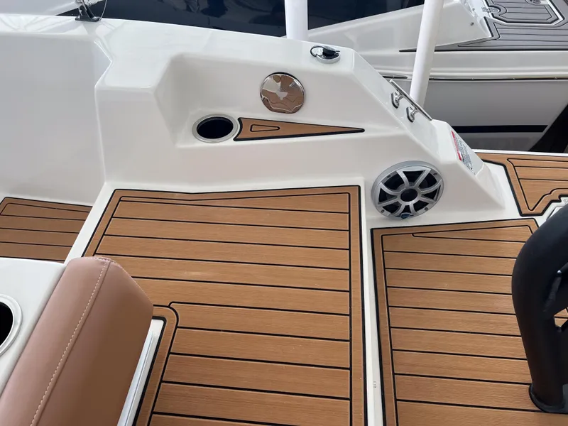 Slide: The Image of 2026 Starcraft SVX 231 OB boat deck with wood finish and speaker detail. - 24