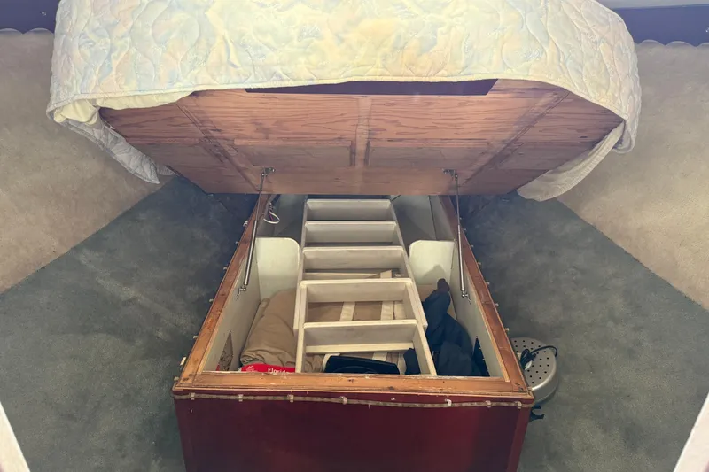 Slide: The Image of Interior storage compartment of a 1984 Custom 38 boat, featuring organized shelves and bedding. - 13