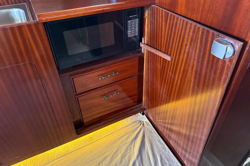 Slide: The Image of Wooden cabinetry with microwave and drawers in 1984 Custom 38 boat interior. - 16
