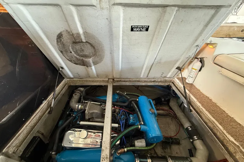 Slide: The Image of Engine compartment of a 1984 Custom 38 boat, featuring blue engine components. - 18