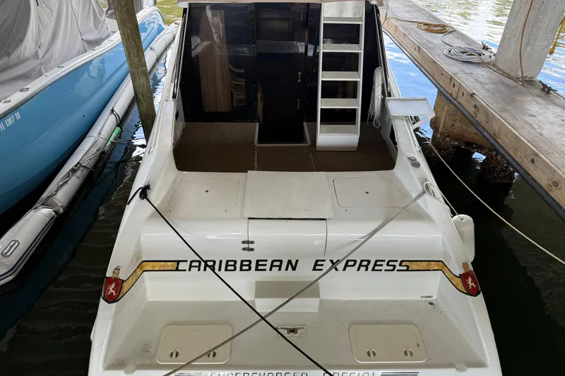 Slide: The Image of 1984 Custom 38 boat named "Caribbean Express" docked in a marina. - 2