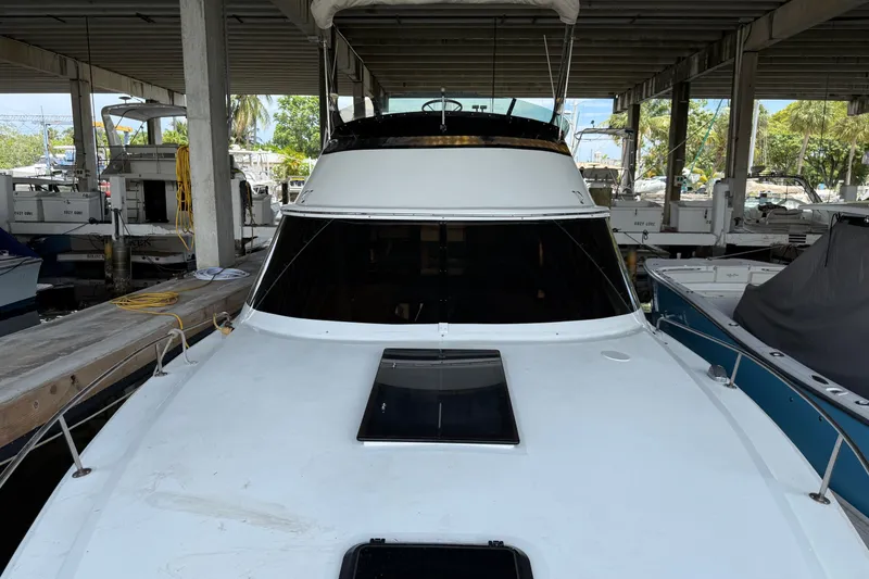 Slide: The Image of 1984 Custom 38 yacht docked in a covered marina, front view. - 4