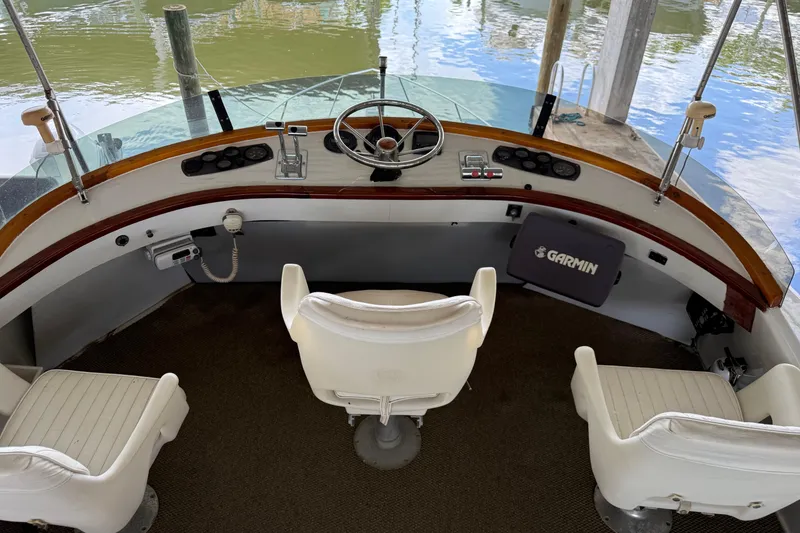 Slide: The Image of Cockpit of 1984 Custom 38 boat with steering wheel, Garmin device, and three white seats. - 5