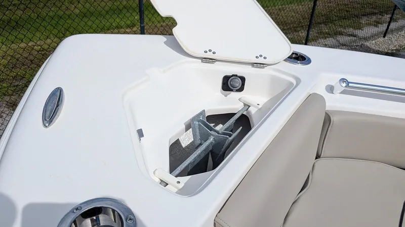 Slide: The Image of 2026 Key West 219 FS boat anchor compartment with open lid, showcasing storage space. - 16