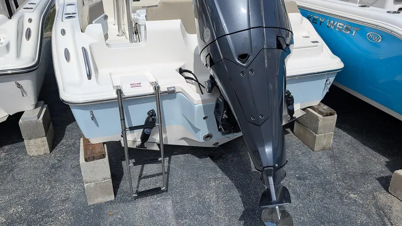 Slide: The Image of 2026 Key West 219 FS boat with outboard motor and ladder on display. - 6