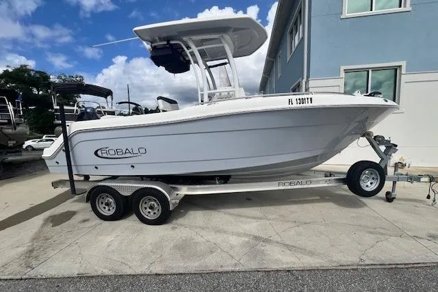 The Image of 2022 Robalo R222 Center Console boat on trailer, parked outdoors. - 0