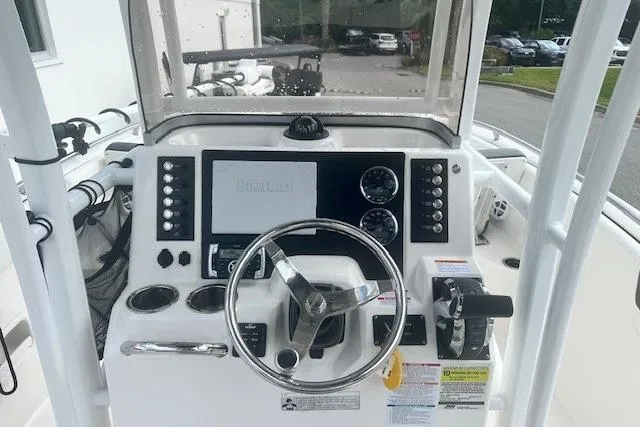 Slide: The Image of 2022 Robalo R222 Center Console boat dashboard with steering wheel and controls. - 6