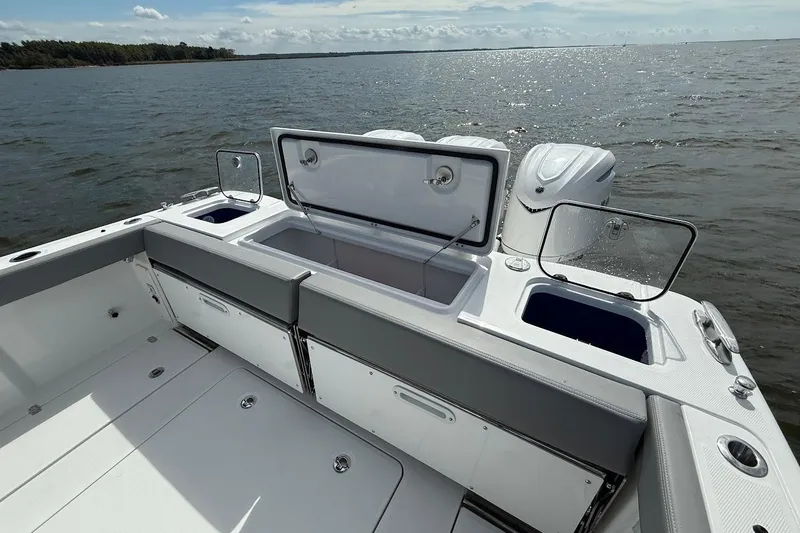 Slide: The Image of 2026 Everglades 375 Center Console boat with open storage compartments on a calm sea. - 10