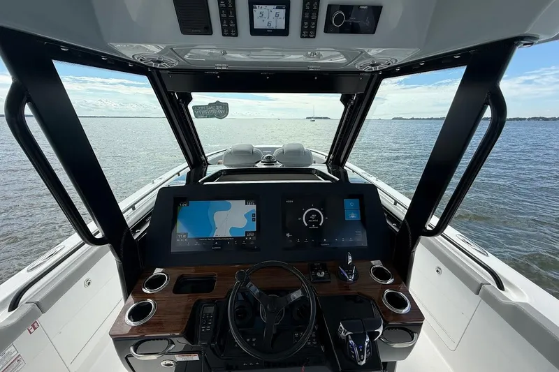 Slide: The Image of 2026 Everglades 375 Center Console boat dashboard with navigation screens on open water. - 21