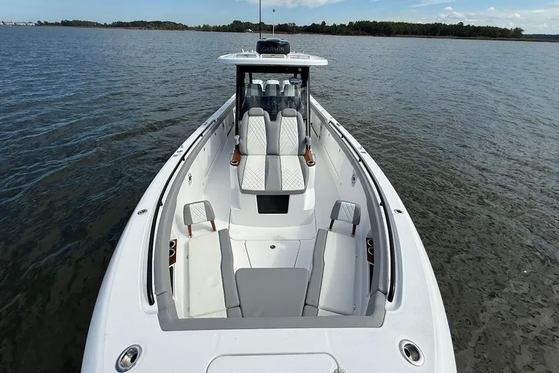 Slide: The Image of 2026 Everglades 375 Center Console boat on calm water, showcasing spacious seating and sleek design. - 37
