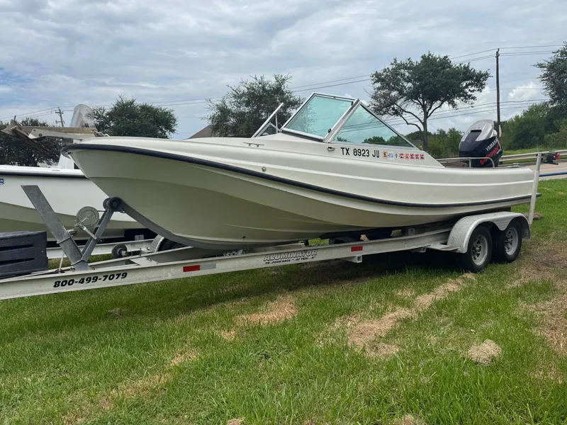 The Image of 1978 Boston Whaler 21 Outrage boat on trailer, parked on grass. - 0