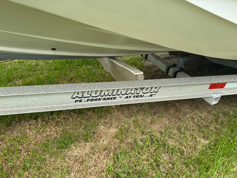 Slide: The Image of 1978 Boston Whaler 21 Outrage on AlumnaTor trailer, parked on grass. - 2