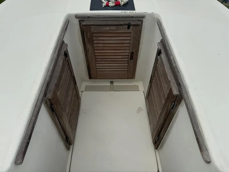 Slide: The Image of 1978 Boston Whaler 21 Outrage boat cabin with wooden doors and white interior. - 20