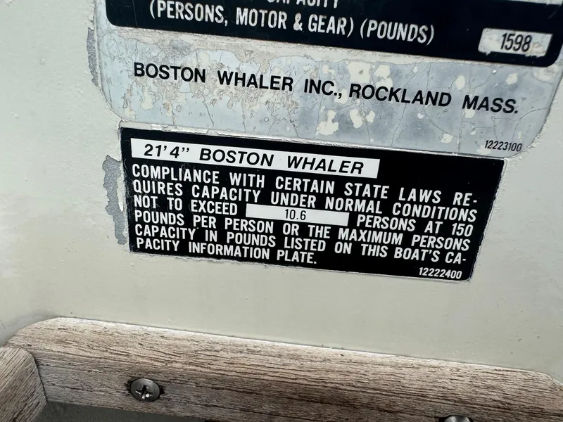 Slide: The Image of 1978 Boston Whaler 21 Outrage capacity plate detailing passenger and weight limits. - 25