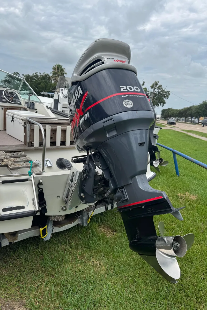 Slide: The Image of 1978 Boston Whaler 21 Outrage with Yamaha 200 HP outboard motor, parked on grass. - 26