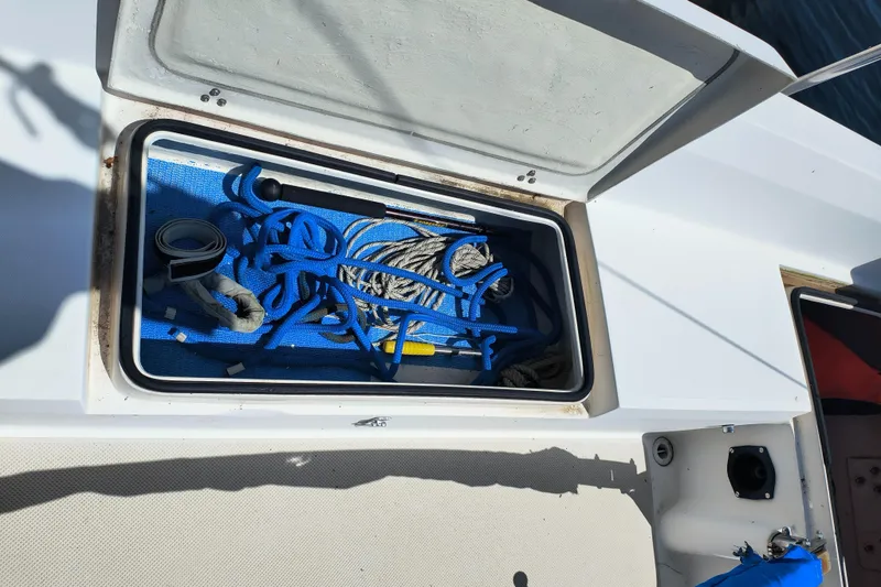Slide: The Image of Open storage compartment on 1985 Catalina 27 sailboat with ropes and tools. - 10