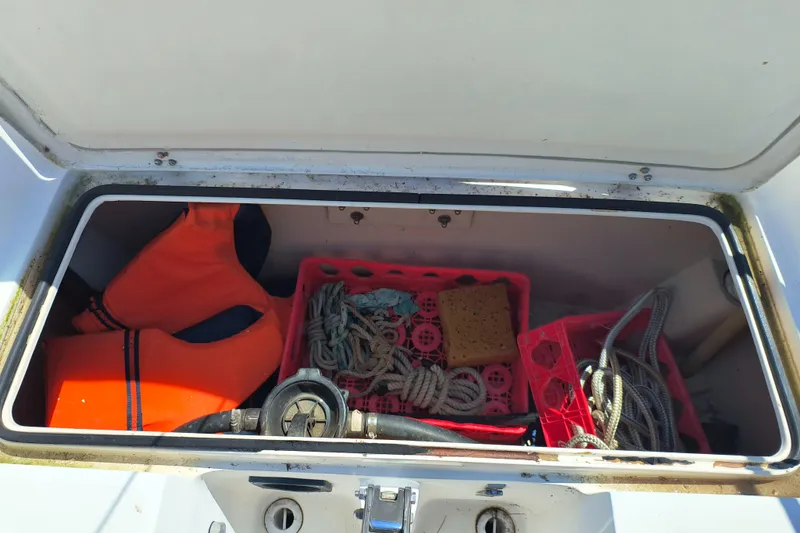 Slide: The Image of Open storage compartment on 1985 Catalina 27 boat with life jackets and ropes. - 12