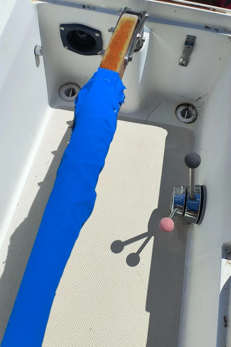 Slide: The Image of 1985 Catalina 27 sailboat cockpit with blue tiller cover and control lever. - 13