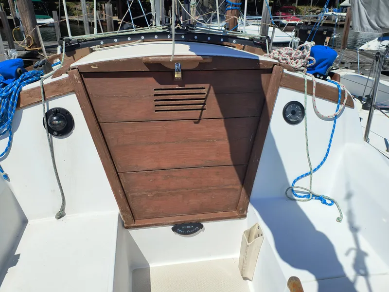 Slide: The Image of 1985 Catalina 27 sailboat cockpit with wooden hatch and nautical ropes. - 15