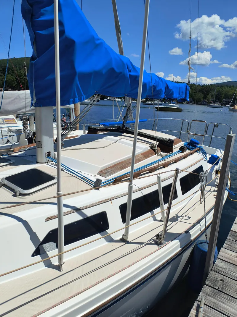 Slide: The Image of 1985 Catalina 27 sailboat docked with blue sail cover, sunny day. - 2
