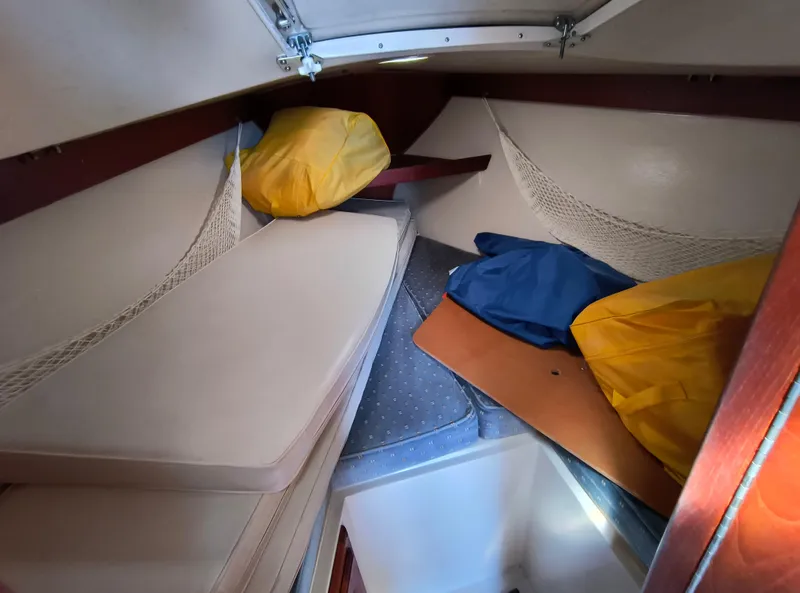 Slide: The Image of Interior cabin of a 1985 Catalina 27 sailboat with cushions and storage bags. - 25