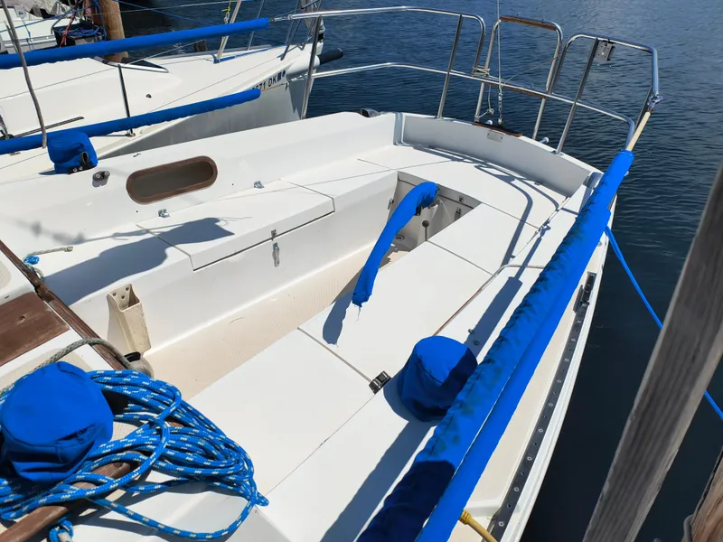 Slide: The Image of 1985 Catalina 27 sailboat with blue accents docked at a marina. - 7