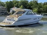 Slide: The Image of 2010 Regal 46 Sport Coupe docked, featuring teak deck and covered cabin. - 13