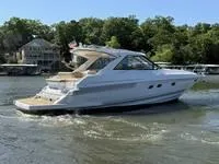 Slide: The Image of 2010 Regal 46 Sport Coupe yacht docked, featuring a covered deck and sleek design. - 14