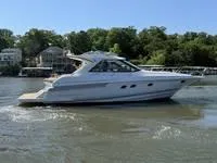 Slide: The Image of 2010 Regal 46 Sport Coupe yacht docked in a marina, featuring sleek design and spacious deck. - 15