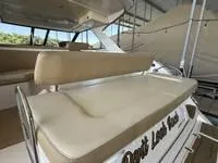 Slide: The Image of 2010 Regal 46 Sport Coupe yacht bow with sunpad, docked on calm water. - 17