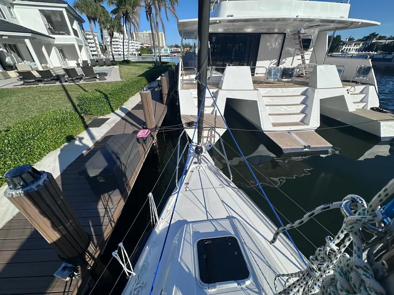Slide: The Image of Sailboat docked near luxury waterfront property, Maxus 26, 2025 model, sunny day. - 8
